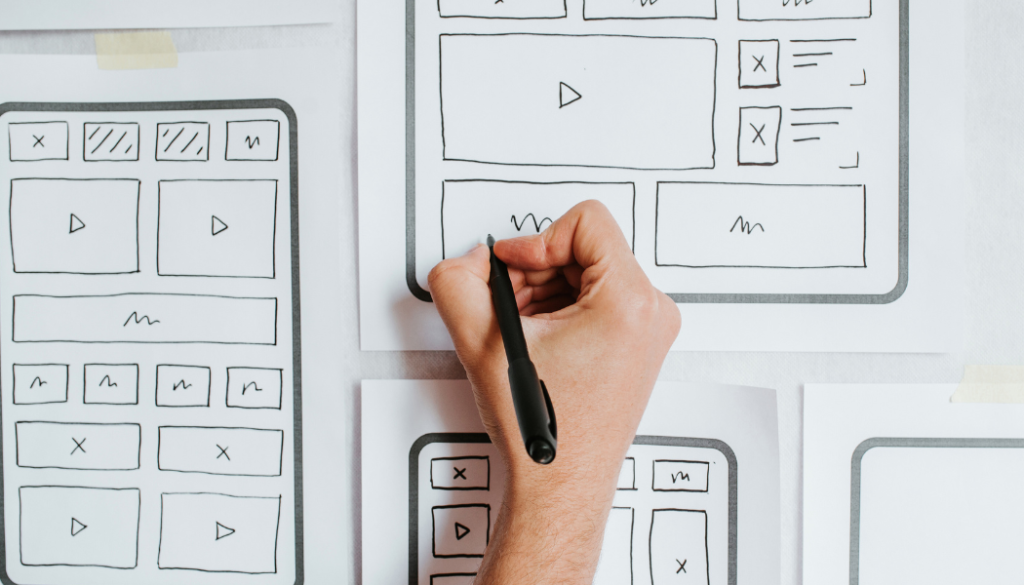 a hand drawing a wireframe for a tablet version of an application.